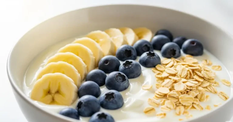 Tigela de iogurte com banana e aveia, mostrando a diferença entre probióticos e prebióticos de forma prática.